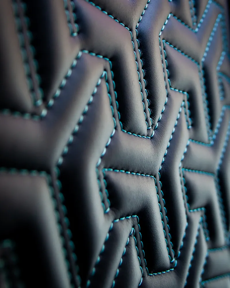 Diamond-quilted leather upholstery with blue contrast stitching